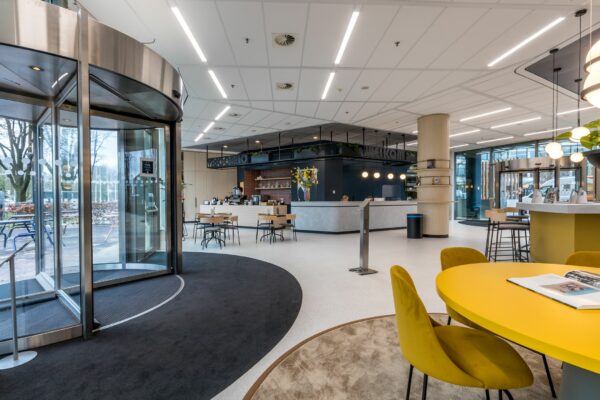 Moderne en lichte ontvangsthal aan de Vliegend Hertlaan 21 met zitjes, balie en koffieruimte.