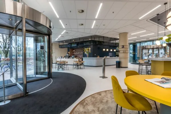 Moderne en lichte ontvangsthal aan de Vliegend Hertlaan 21 met zitjes, balie en koffieruimte.