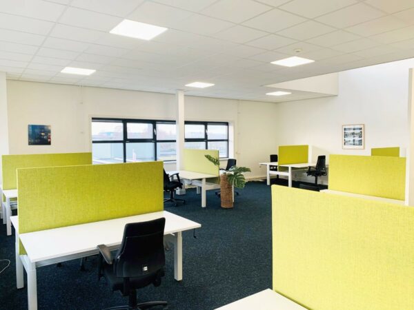 Moderne kantoorruimte aan de Waarderweg 25 met meerdere werkplekken en groene scheidingswanden.