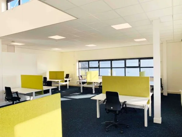 Ruim en licht kantoor aan de Waarderweg 33 met meerdere werkplekken en groene scheidingswanden.