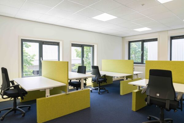 Moderne kantoorruimte aan de Waarderweg 33 met verstelbare bureaus, ergonomische stoelen en groene scheidingswanden.