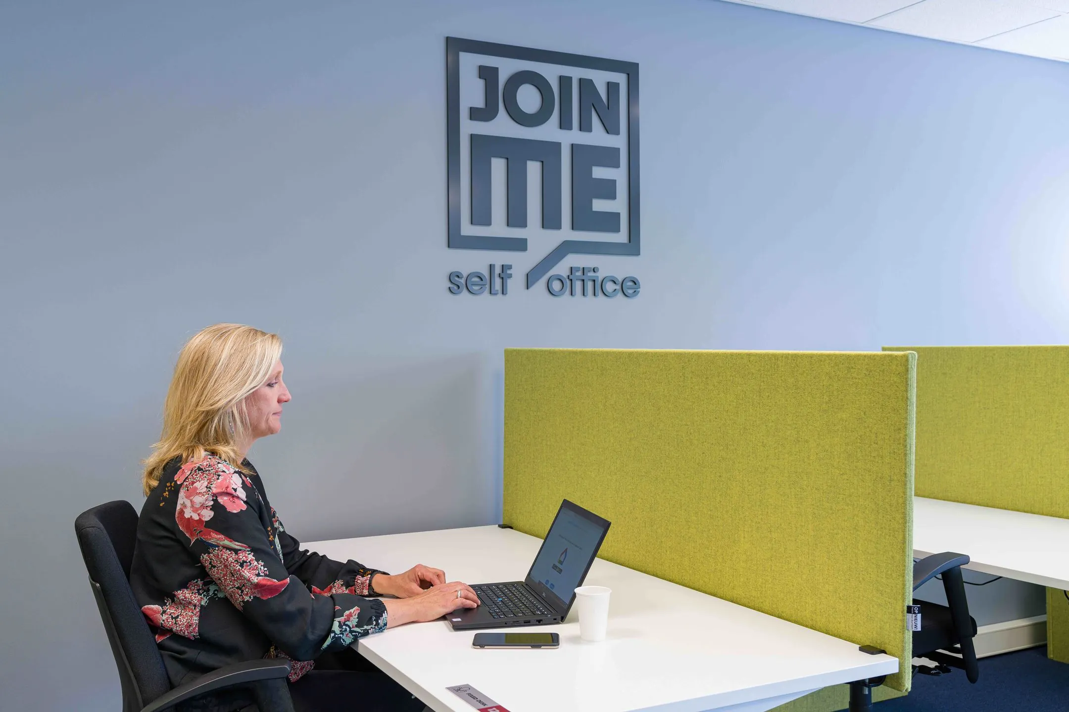 Vrouw werkt op een laptop in een moderne kantoorruimte bij Join ME self office aan de Waarderweg 33.