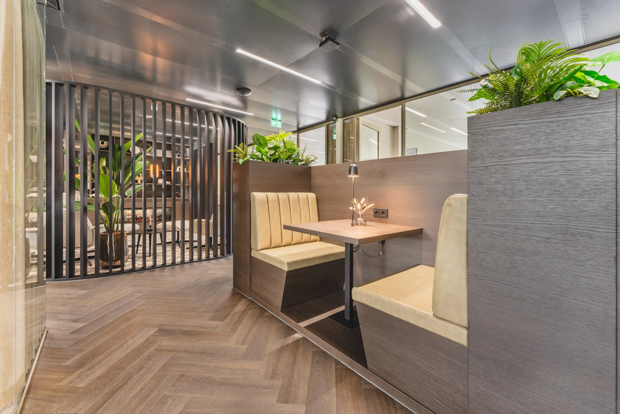 Moderne kantoorruimte Walborg met een houten zitnis, gestoffeerde banken, planten en sfeervolle verlichting.