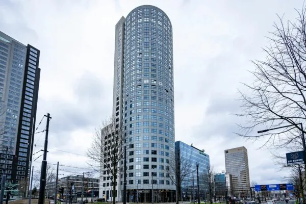 Hoog kantoorgebouw Weena 335 in Rotterdam met ronde gevel, gefotografeerd vanaf straatniveau.
