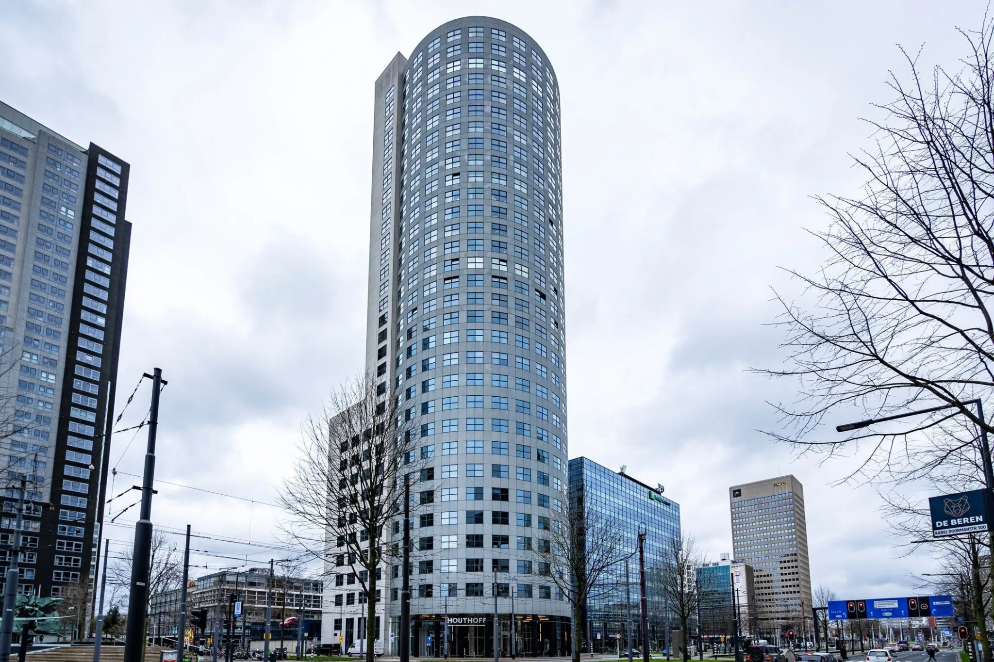 Hoog kantoorgebouw Weena 335 in Rotterdam met ronde gevel, gefotografeerd vanaf straatniveau.
