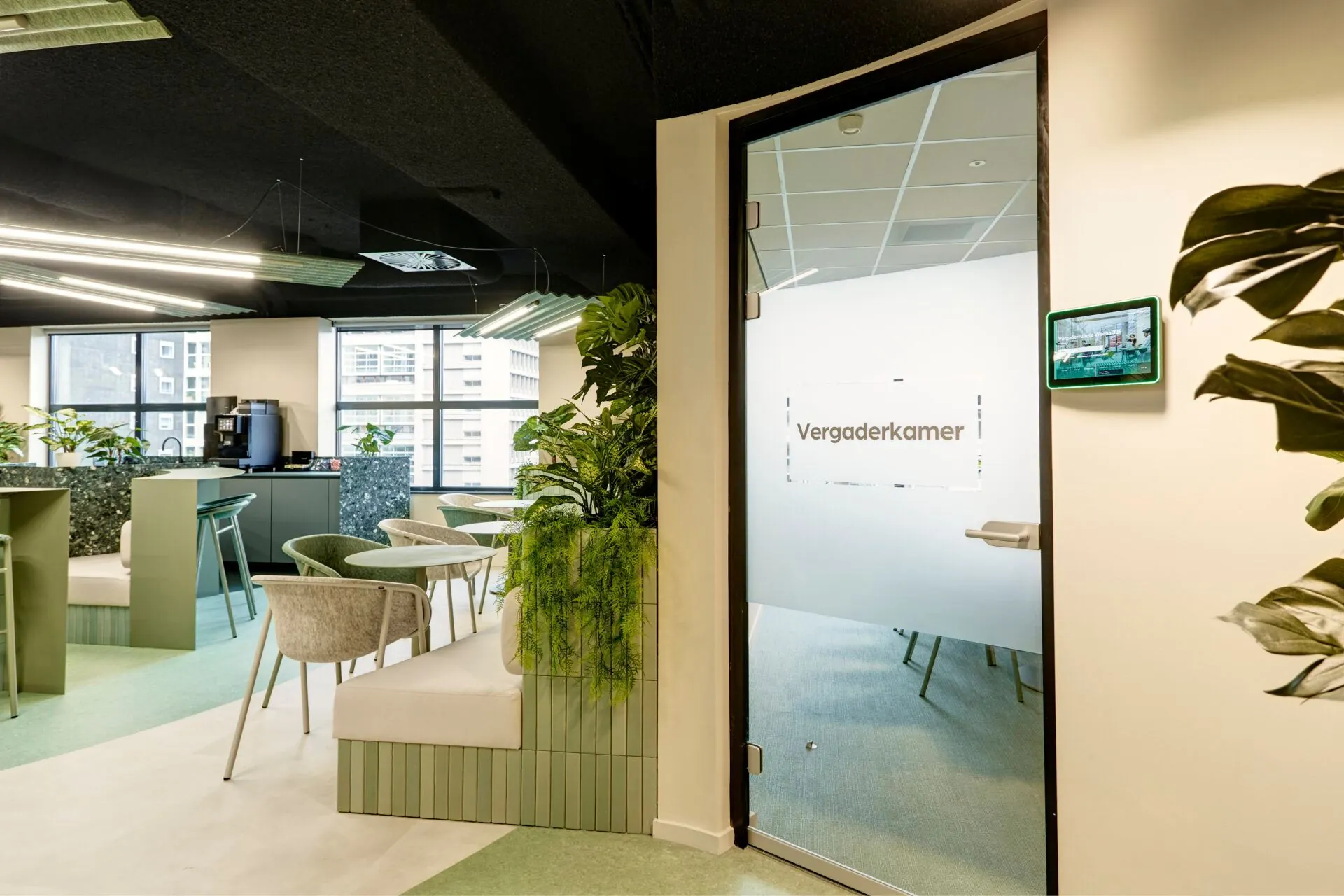 Moderne, groen aangeklede kantoorruimte met zitplekken en een vergaderkamer met glazen deur op Weena 335.