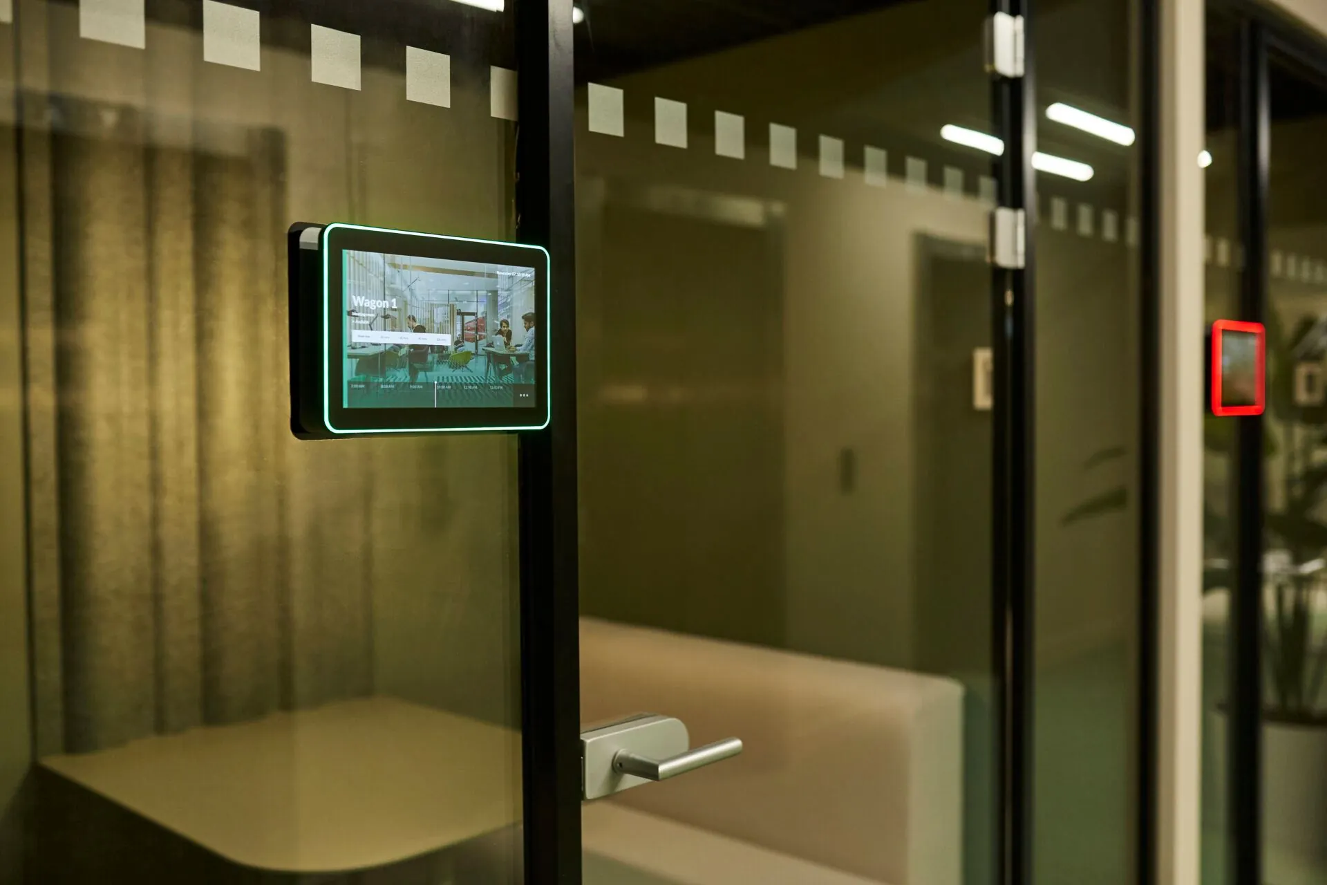 Digitale displays bij vergaderruimtes in kantoorgebouw Weena 335 geven de beschikbaarheid van de kamers aan.