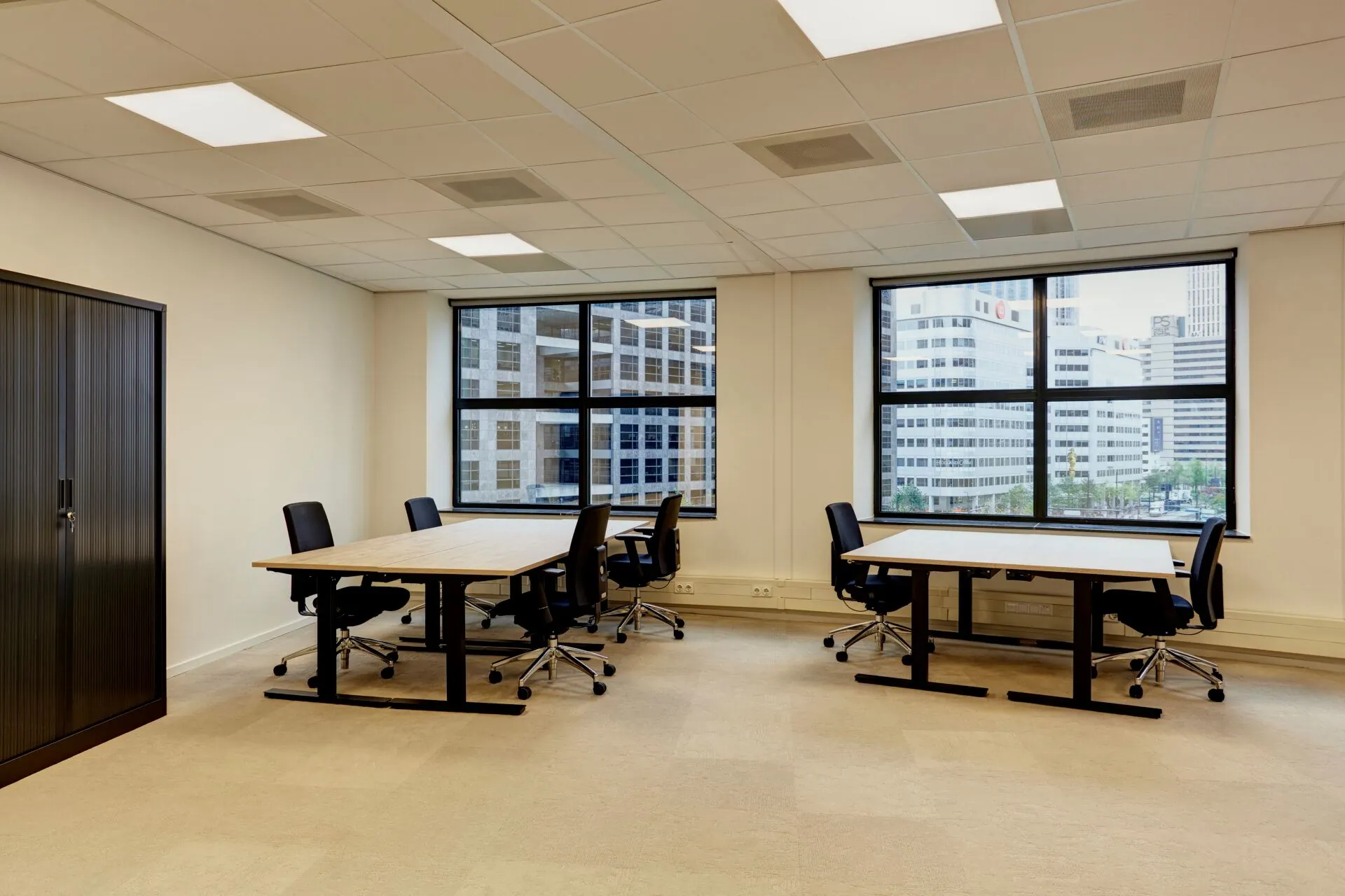 Moderne kantoorruimte aan Weena 335 met bureaus, stoelen en uitzicht op omliggende kantoorpanden.