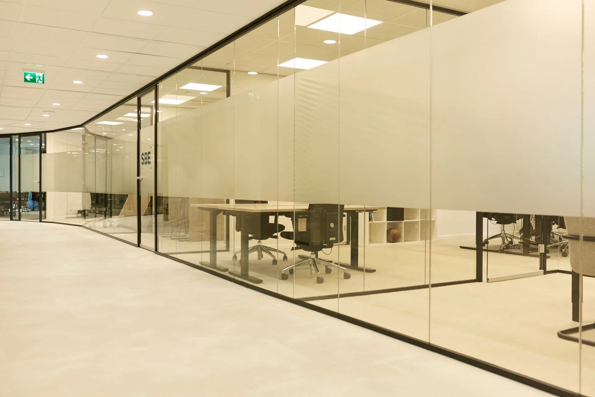 Moderne kantoorruimte aan Weena 335 met glazen wanden en ergonomische bureaustoelen.