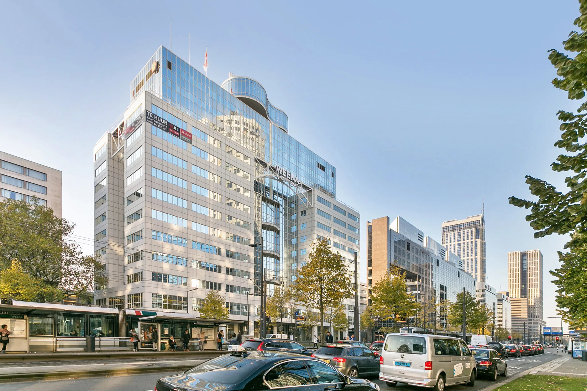 Zakelijk kantoorgebouw Weena 70 in Rotterdam met druk stadsverkeer en een tramhalte op de voorgrond.