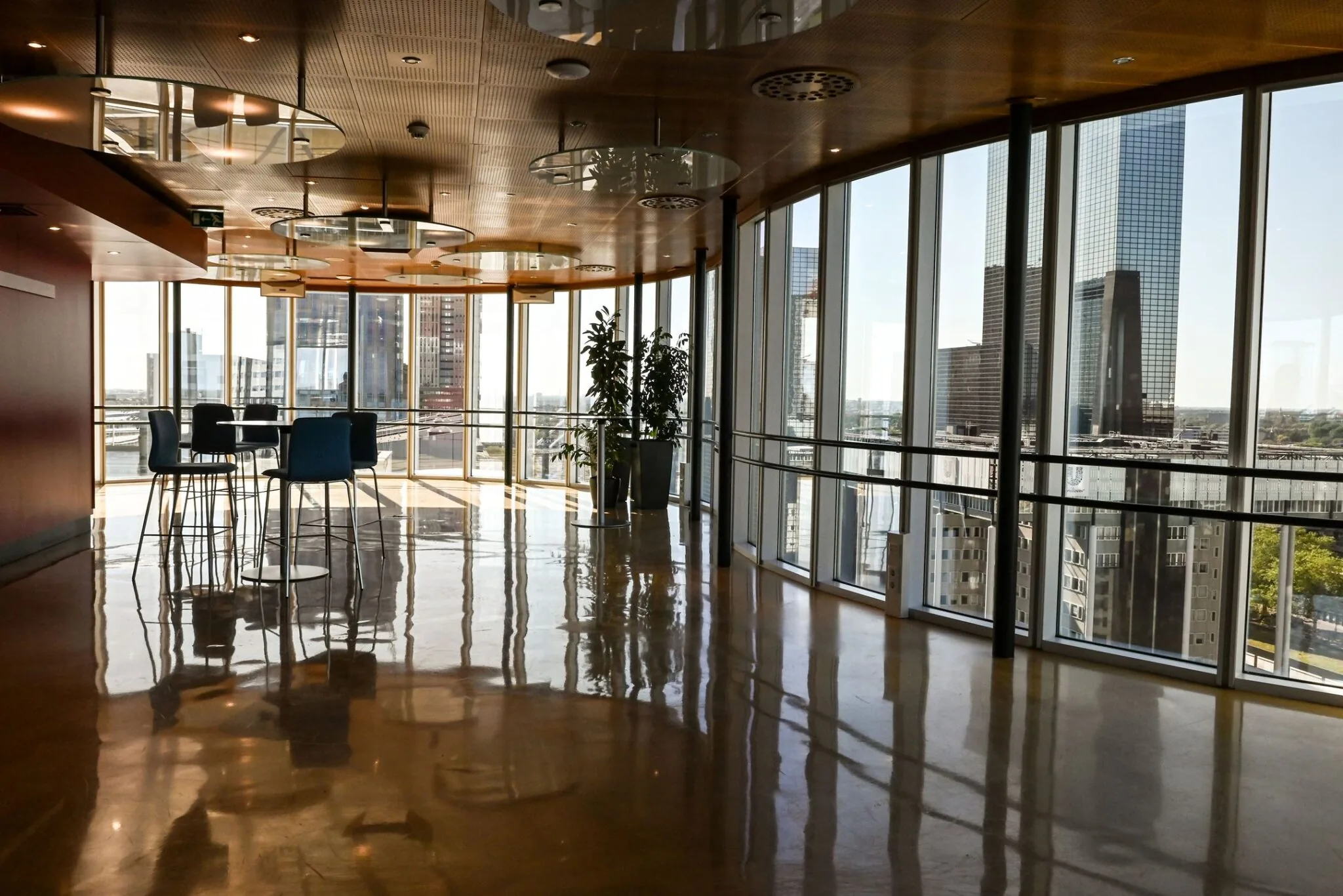 Moderne zithoek met hoge stoelen en panoramisch uitzicht op Rotterdam vanuit Weena 70.