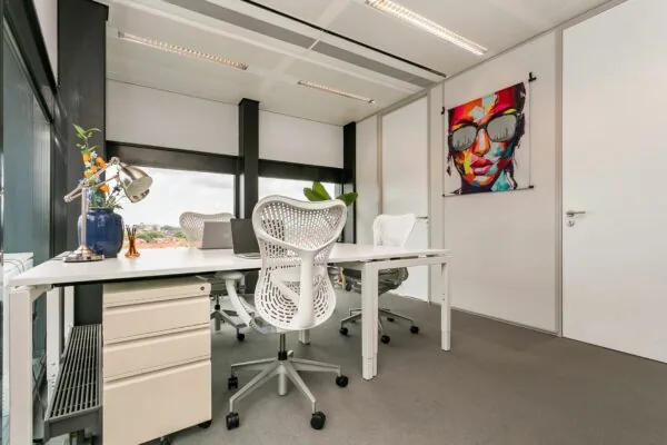 Modern kantoorinterieur op Wim Duisenbergplantsoen 31 met witte bureaus, designstoelen en kleurrijke muurschildering.