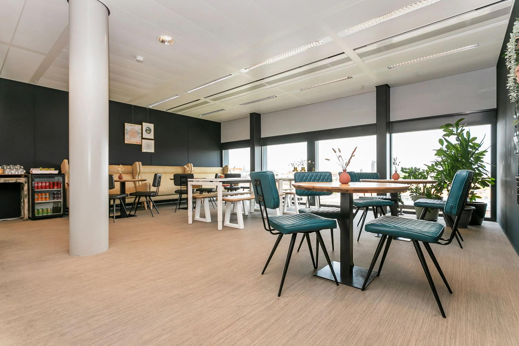 Moderne bedrijfsruimte met zitgedeelte, grote ramen en uitzicht op de stad aan het Wim Duisenbergplantsoen 31.
