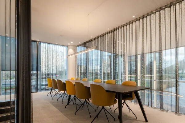 Vergaderruimte in de Zuidtoren met gele stoelen, grote ramen en moderne verlichting.