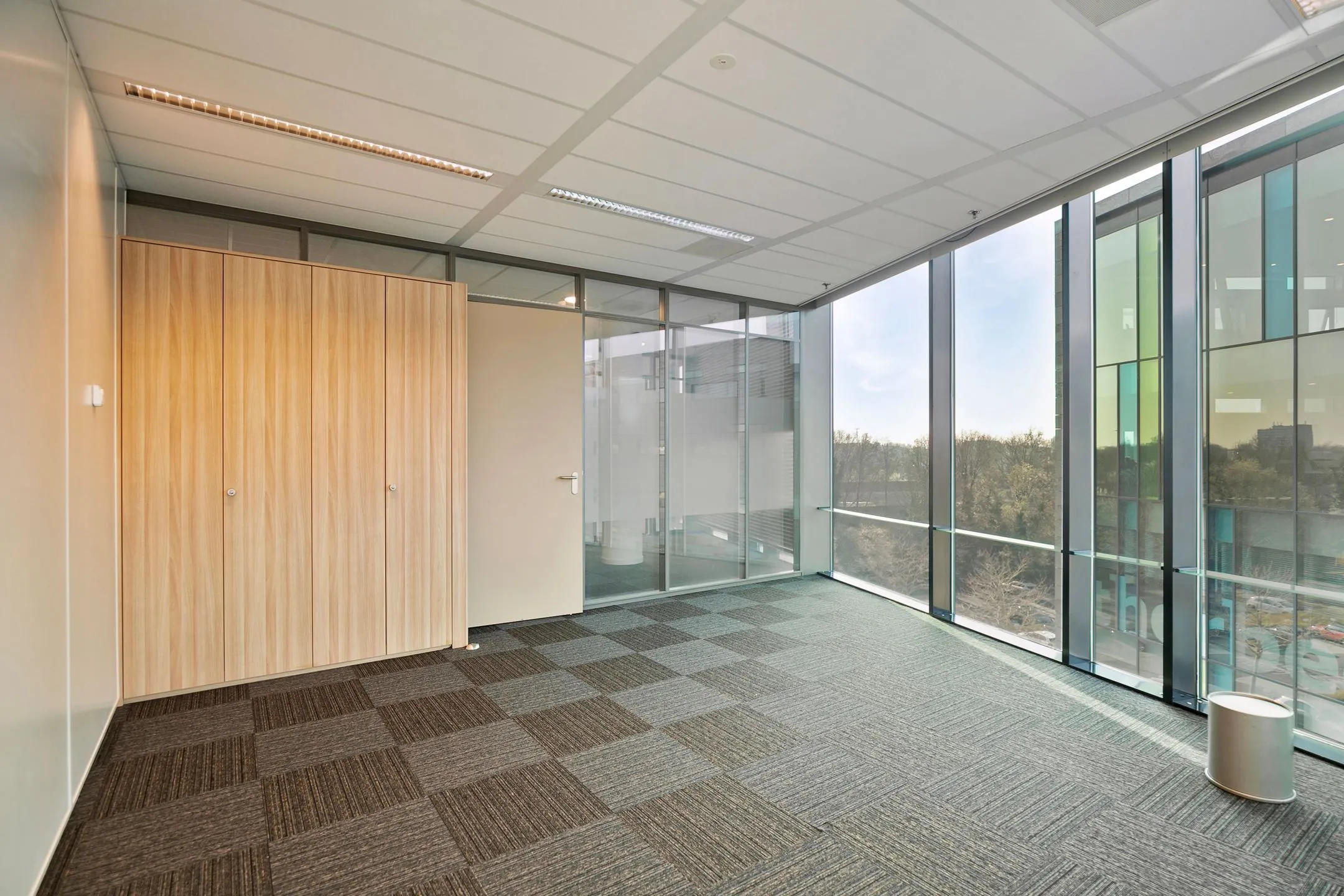 Lichte, moderne kantoorruimte aan de Zwartewaterallee 56 met grote ramen en ingebouwde houten kast.