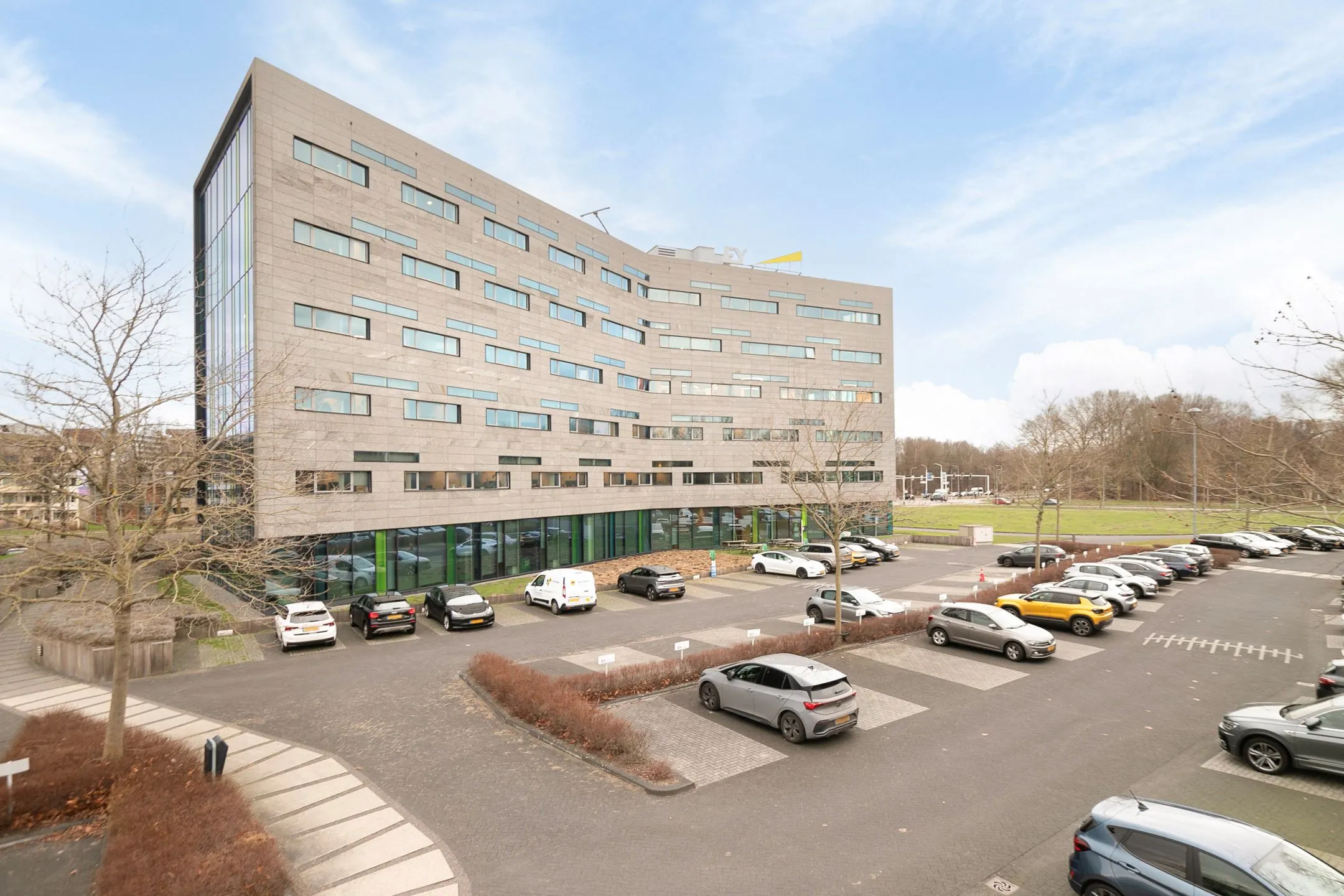 Kantoorgebouw aan de Zwartewaterallee 56 met parkeerterrein op de voorgrond.