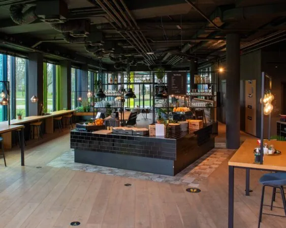 Moderne, sfeervol ingerichte horecaruimte aan de A28 bij Zwolle met een centraal buffet en grote ramen.