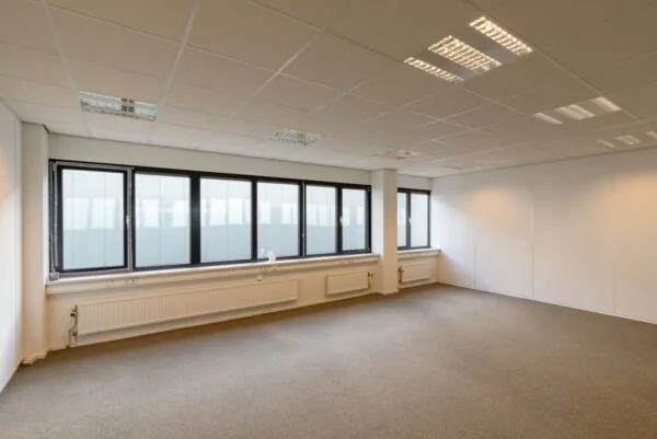 Leeg kantoorruimte met tapijt, systeemplafond en grote ramen aan de Atoomweg 350.