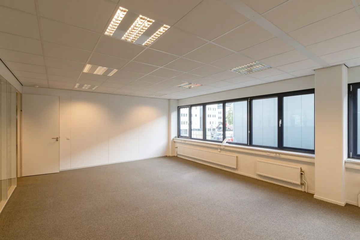 Lichte, lege kantoorruimte aan de Atoomweg 350 met grote ramen en systeemplafond.
