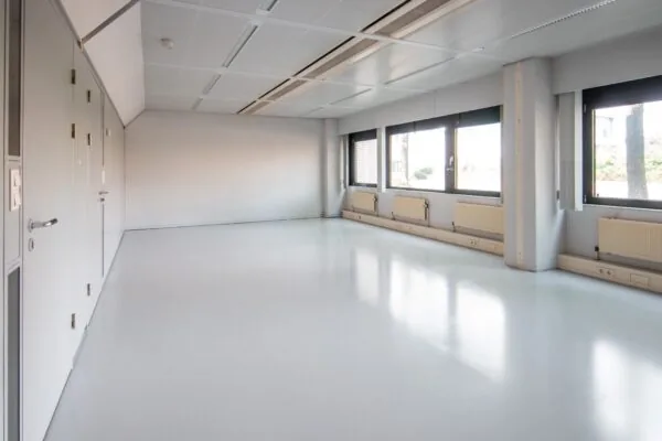 Lichte, lege kantoorruimte aan de Bernadottelaan met grote ramen en witte vloer.