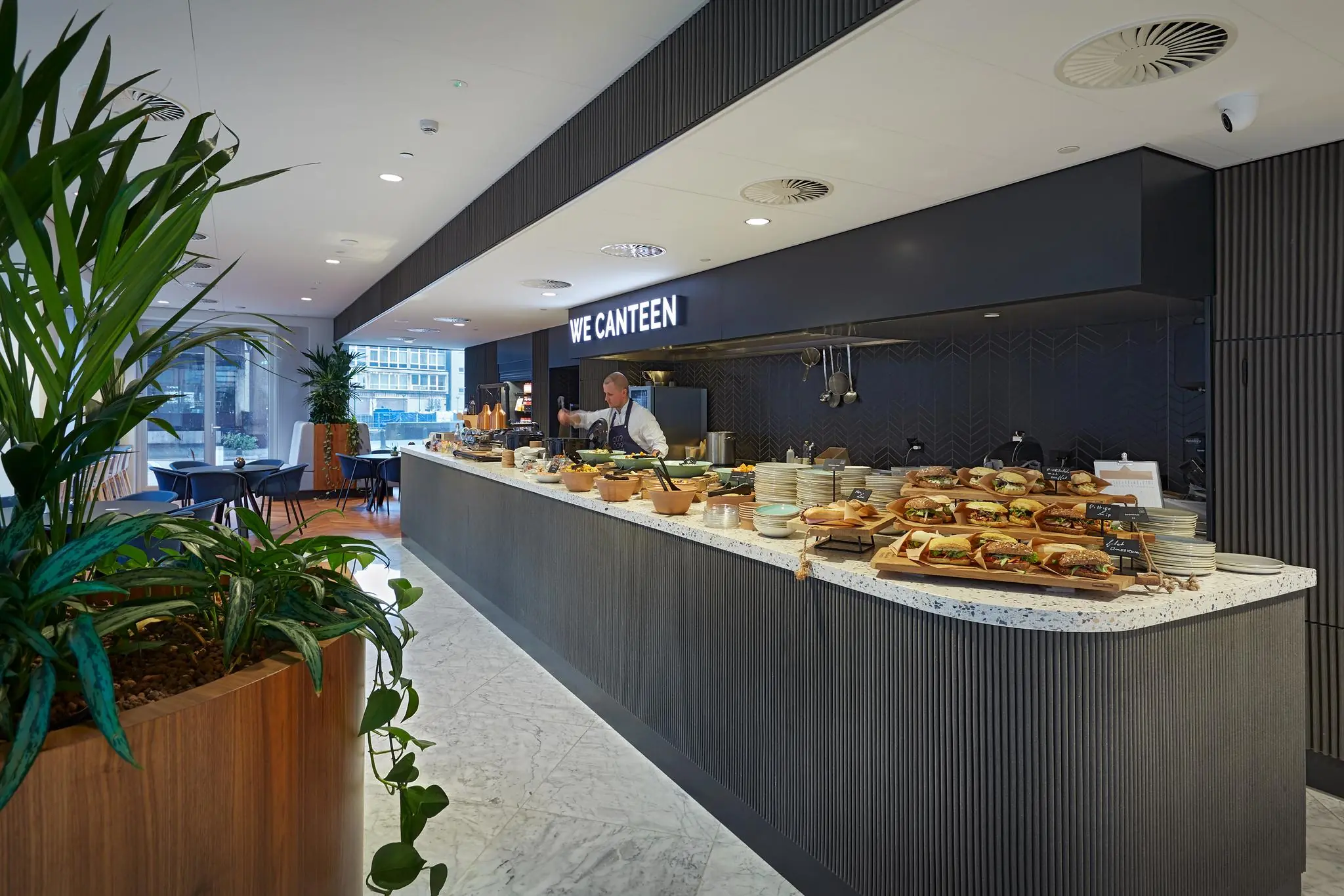 Moderne bedrijfskantine in Blaak 555 met een uitgebreid buffet en zitgelegenheid.