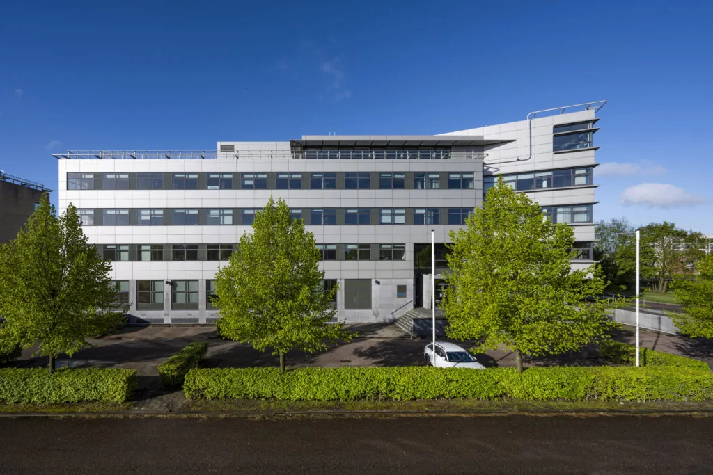 Modern kantoorgebouw aan de Boeing Avenue, omgeven door jonge groene bomen en een geparkeerde witte auto.
