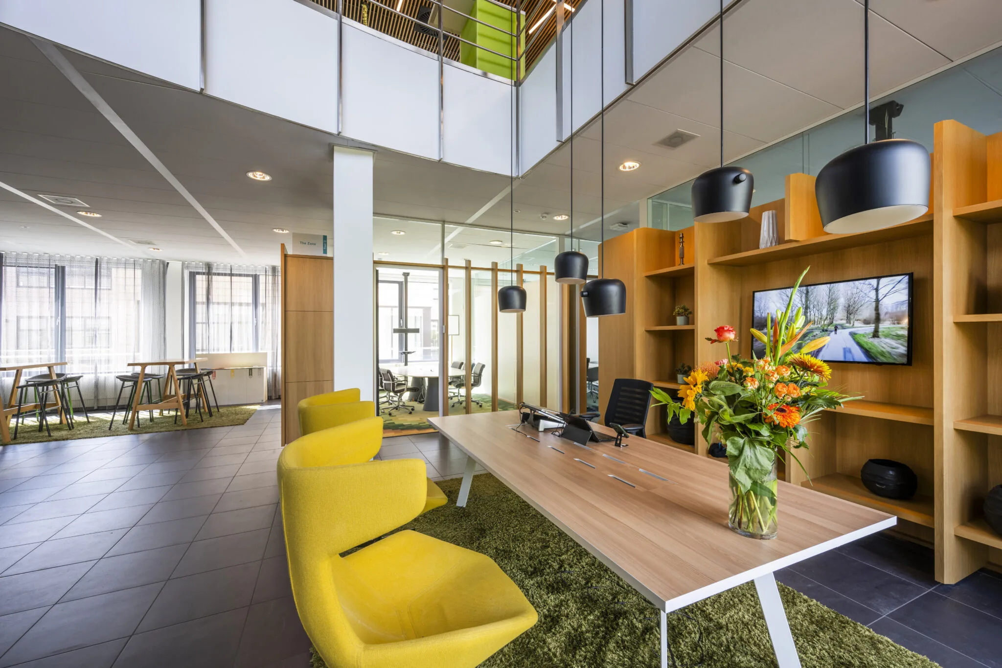 Moderne kantoorruimte aan de Boeing Avenue met houten accenten, gele stoelen en een bloemenboeket op de receptiebalie.
