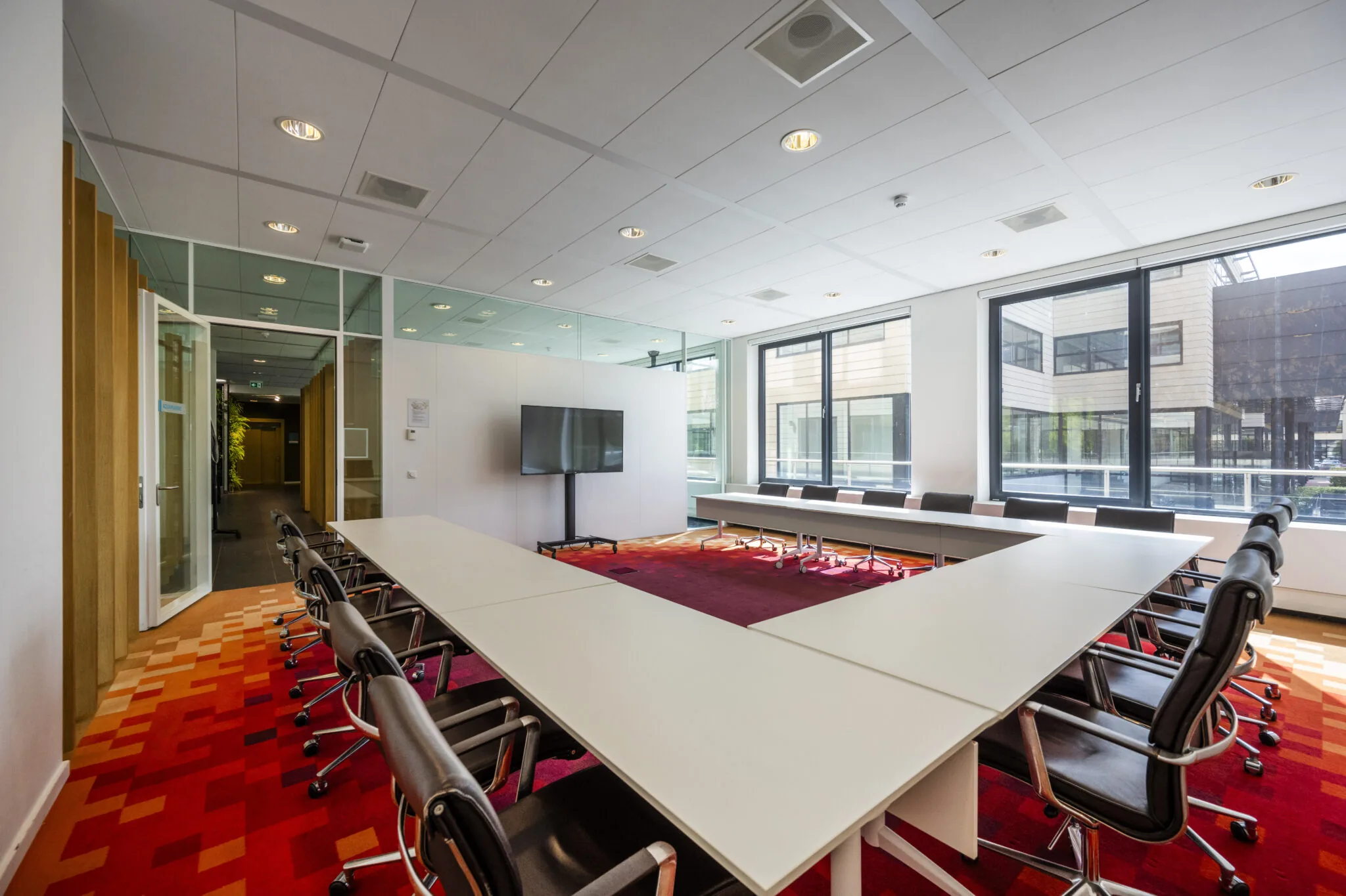 Vergaderruimte met U-vormige opstelling, moderne stoelen en grote ramen aan Boeing Avenue, gefotografeerd door Paul Starink.