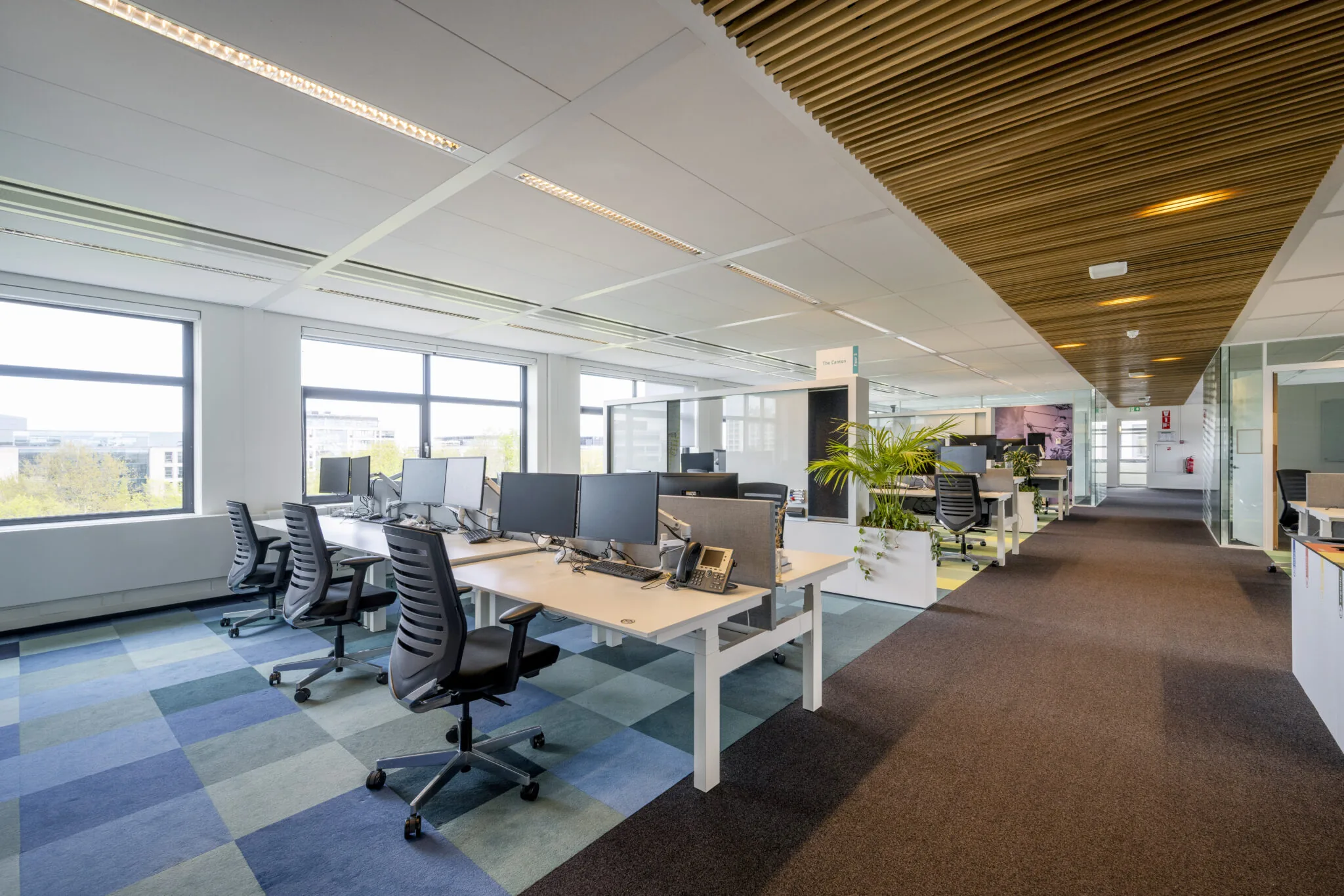 Moderne, open kantoorruimte aan de Boeing Avenue met werkplekken, bureaustoelen en grote ramen.