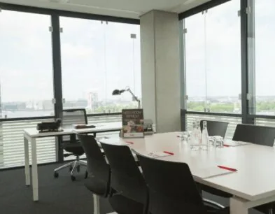 Vergaderruimte met moderne inrichting, grote ramen en uitzicht op de stad.