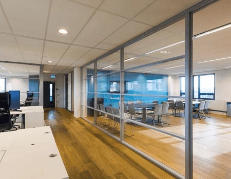 Moderne kantooruimte met glazen vergaderruimte en houten vloer.