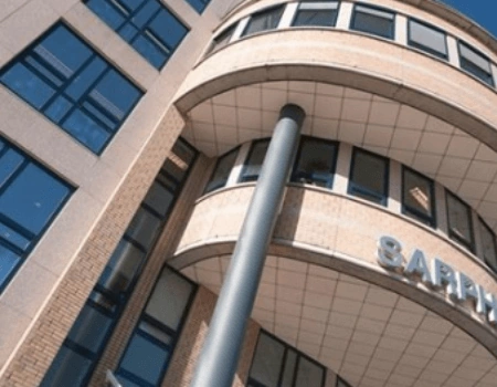 Voorzijde van een modern kantoorgebouw met een rond geveldeel en het deels zichtbare logo van SAP.