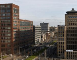 Stadsgezicht met moderne kantoorgebouwen langs een drukke straat in Den Haag.