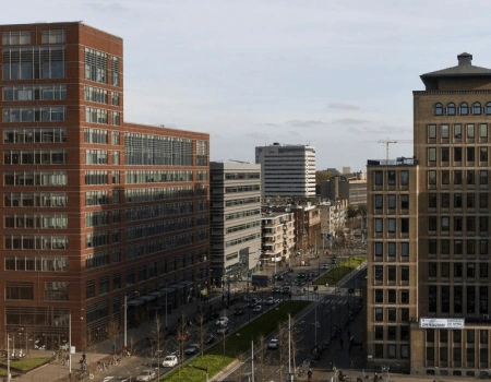 Stadsgezicht met moderne kantoorgebouwen langs een drukke straat in Den Haag.