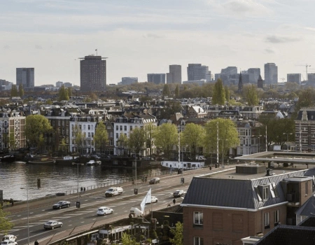 Uitzicht op de skyline van Amsterdam-Zuid met de Zuidas op de achtergrond en de Amstel op de voorgrond.