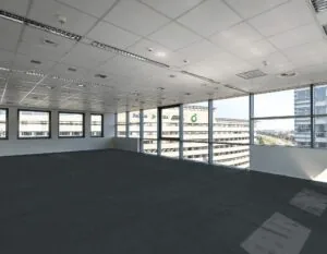 Leeg kantoor met raamuitzicht op omliggende kantoorgebouwen, waaronder het gebouw van BP en Regus.