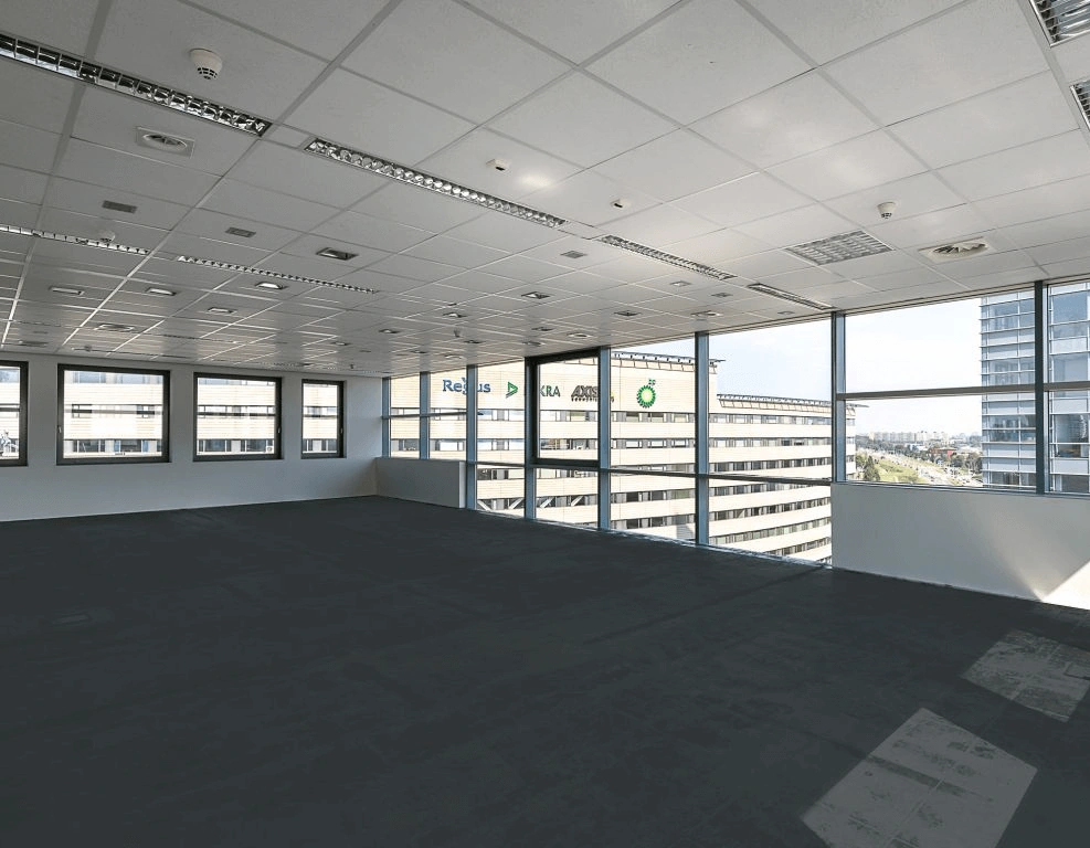 Leeg kantoor met raamuitzicht op omliggende kantoorgebouwen, waaronder het gebouw van BP en Regus.