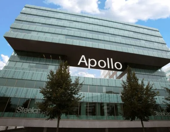 Modern glazen kantoorgebouw met de naam "Apollo" prominent zichtbaar op een uitstekende verdieping.