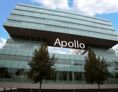Modern kantoorgebouw met de naam "Apollo" prominent op een verhoogde structuur tussen glazen gevels.