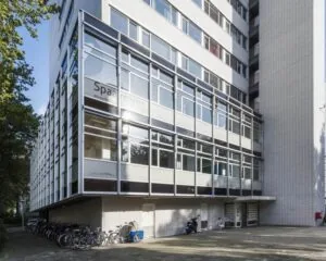 Modern kantoorgebouw met de naam "Spaargaren" op de gevel en fietsen geparkeerd op de stoep ervoor.