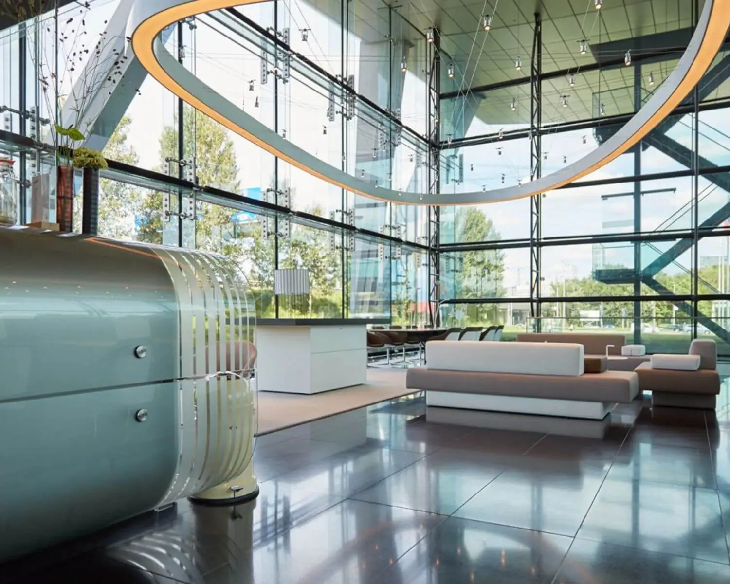 Modern ingerichte, lichte en ruime lobby met glazen wanden en designmeubilair.