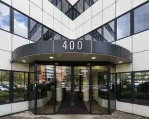 Ingang van een modern kantoorgebouw met het nummer 400 boven de deur.