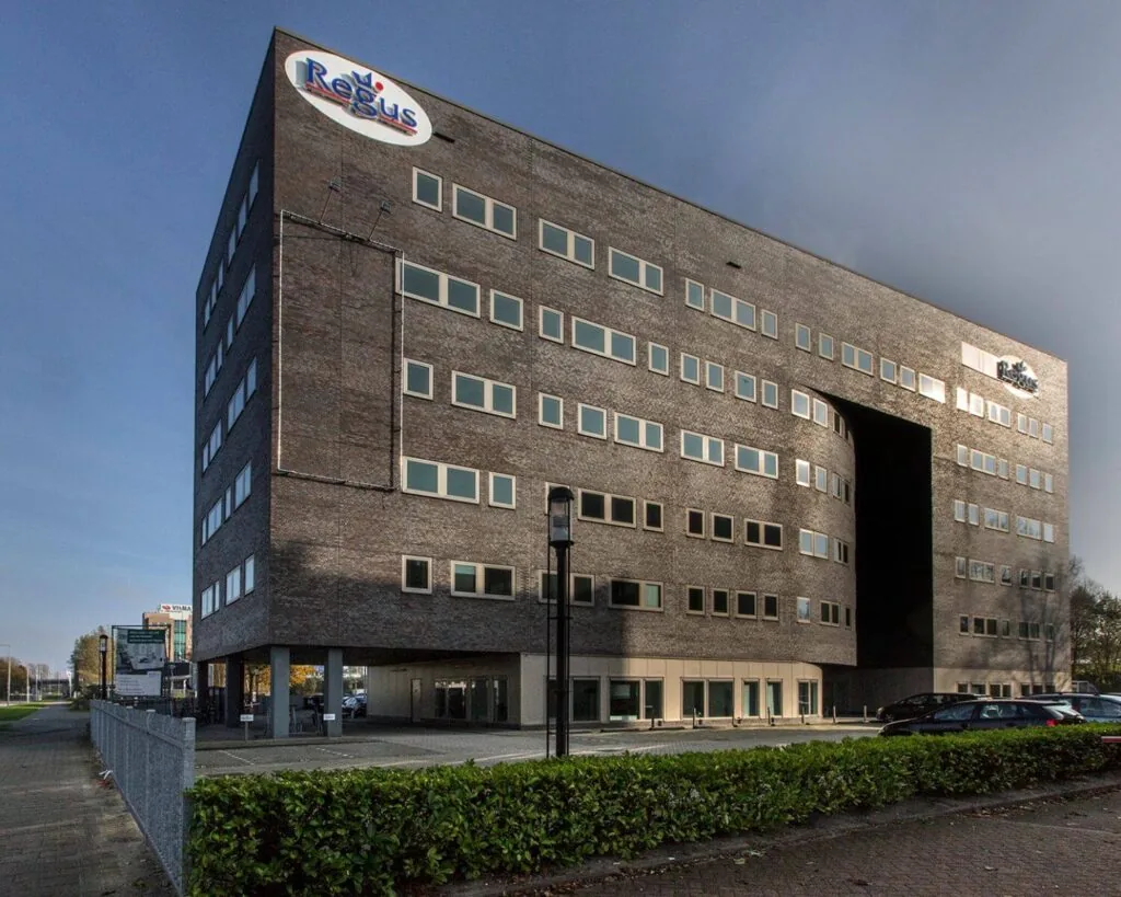 Zakelijk kantoorgebouw van Regus met moderne architectuur en grote uitsparing in het midden.
