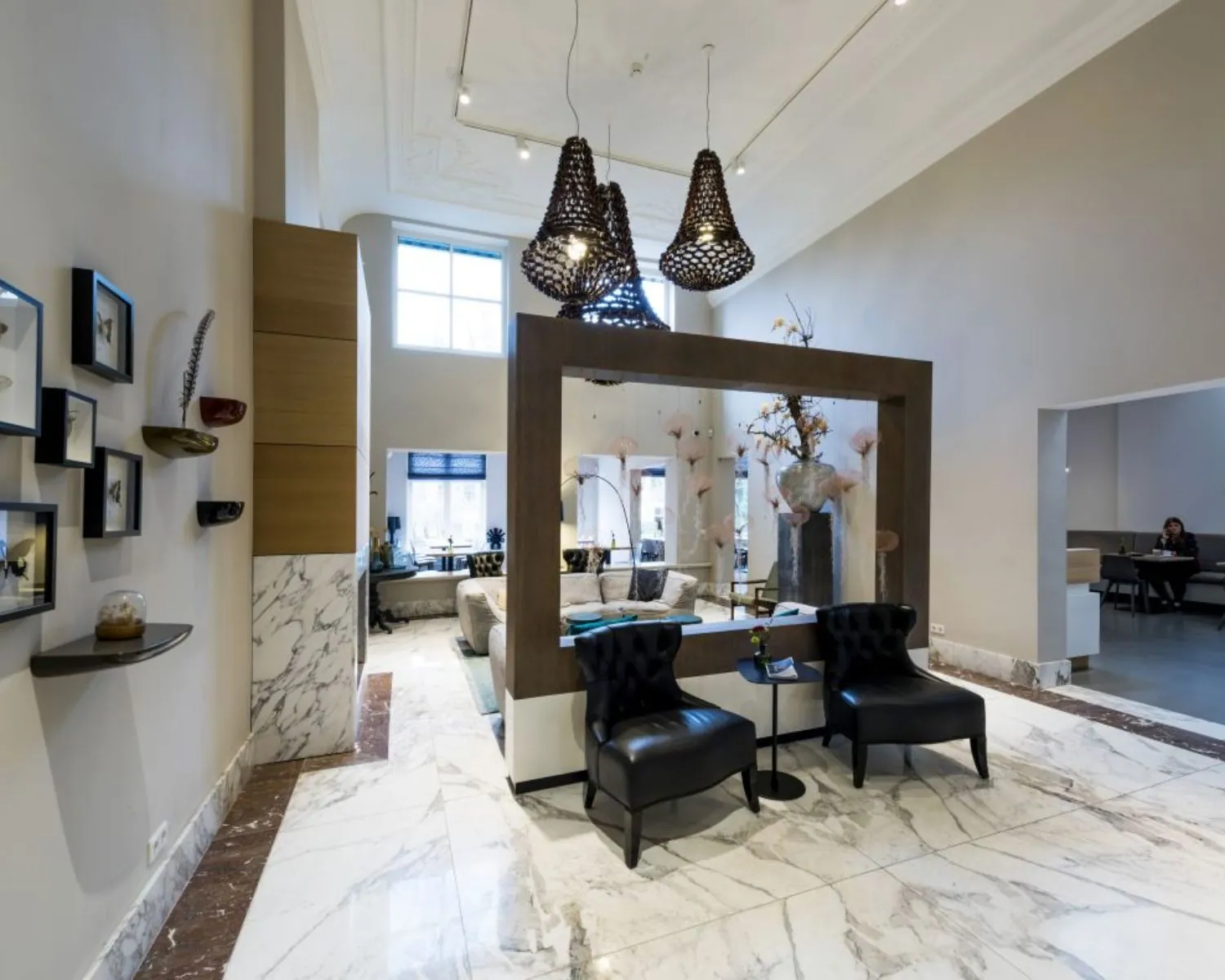 Stijlvol ingerichte hotellobby met marmeren vloer, moderne zitplaatsen en decoratieve verlichting.