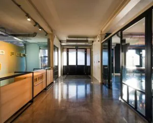 Moderne entreehal van het kledingmerk 10 FEET met glazen deuren en een houten balie.