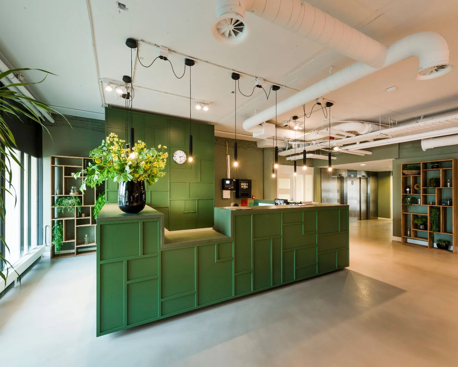 Moderne receptiebalie in een stijlvol kantoorinterieur met groene accenten en industriële details.