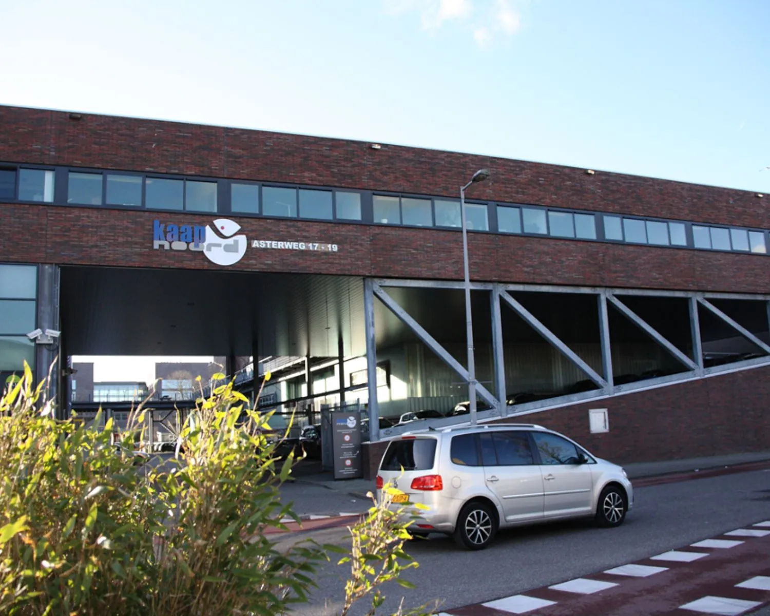 Bedrijfsgebouw Kaap Noord aan de Asterweg 17-19 in Amsterdam met een auto op de voorgrond.