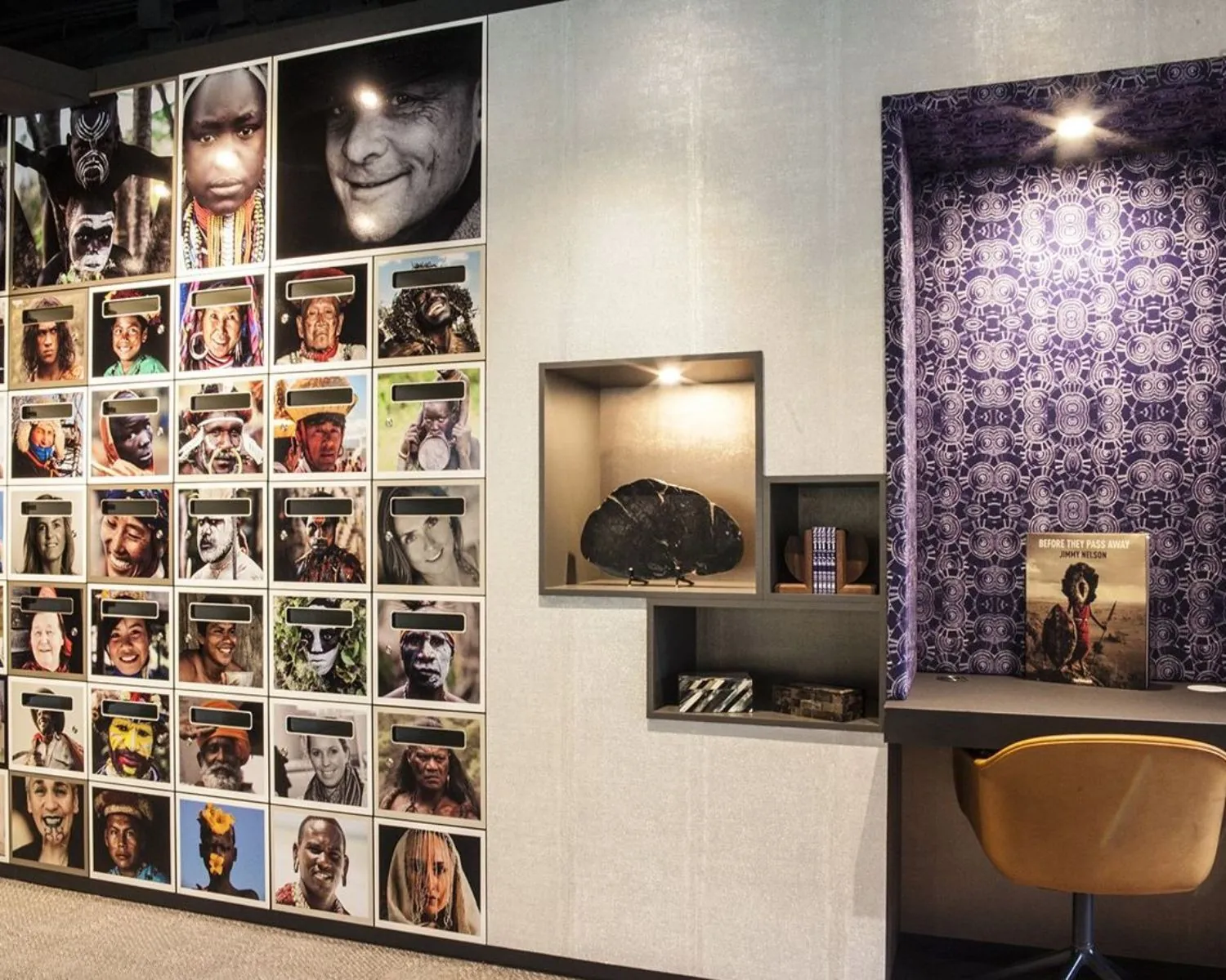 Fotowand met portretten van inheemse volkeren naast een moderne leeshoek met het boek *Before They Pass Away* van Jimmy Nelson.