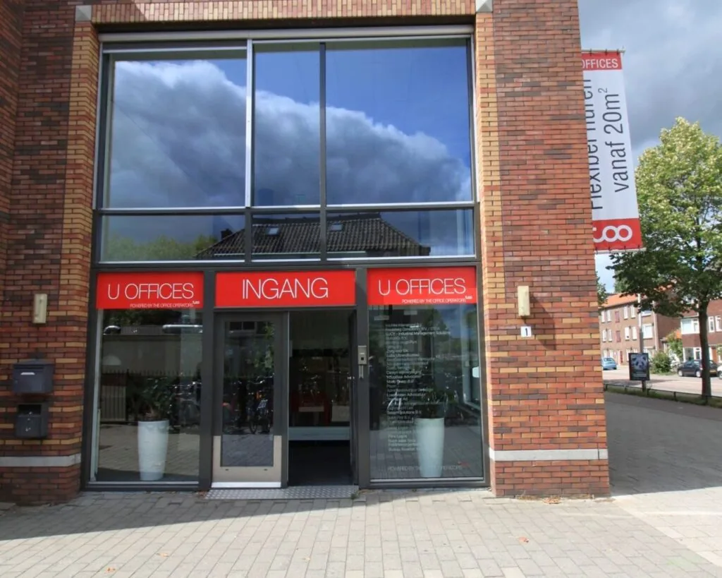 Ingang van U Offices in een modern rood-bruin bakstenen gebouw met grote ramen.