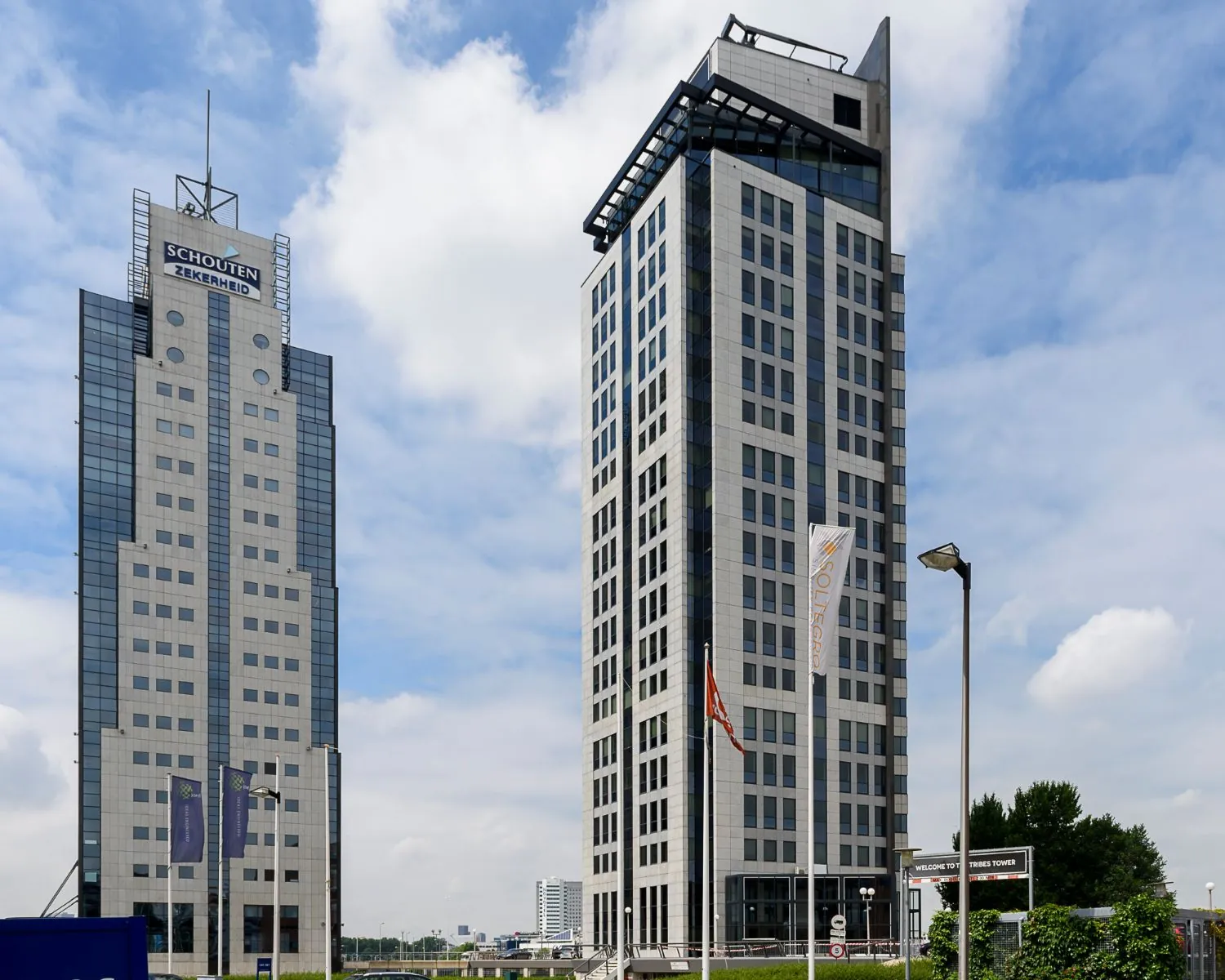 Twee moderne kantoortorens in Rotterdam met zichtbare namen "Schouten Zekerheid" en "Tribes Tower".